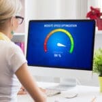 Woman at a computer viewing a website speed optimization gauge
