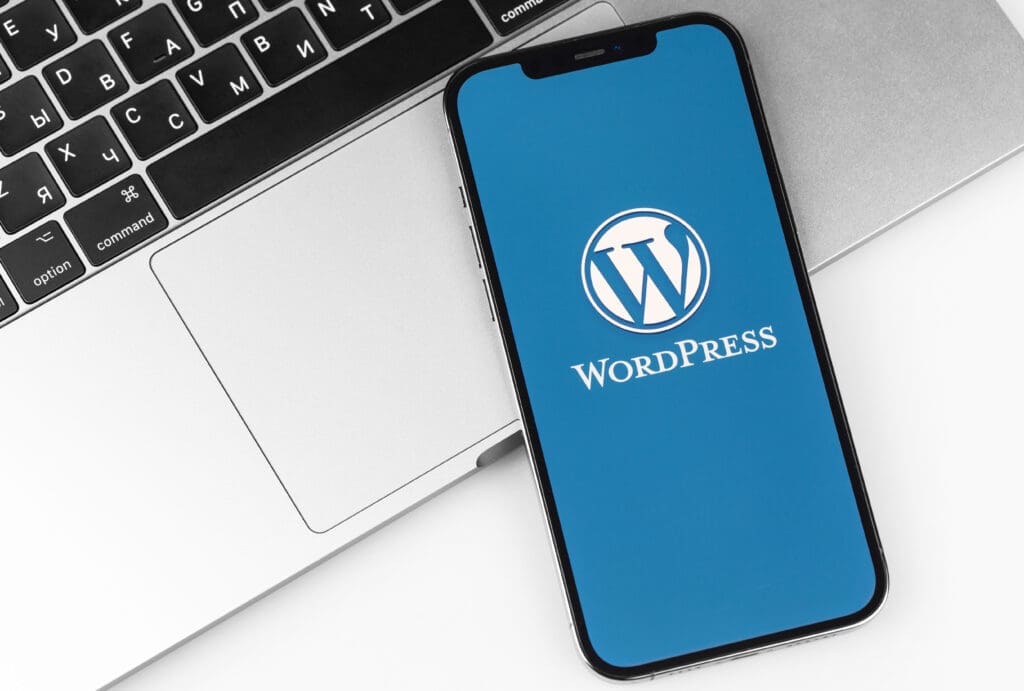 Smartphone displaying the WordPress logo on a laptop keyboard