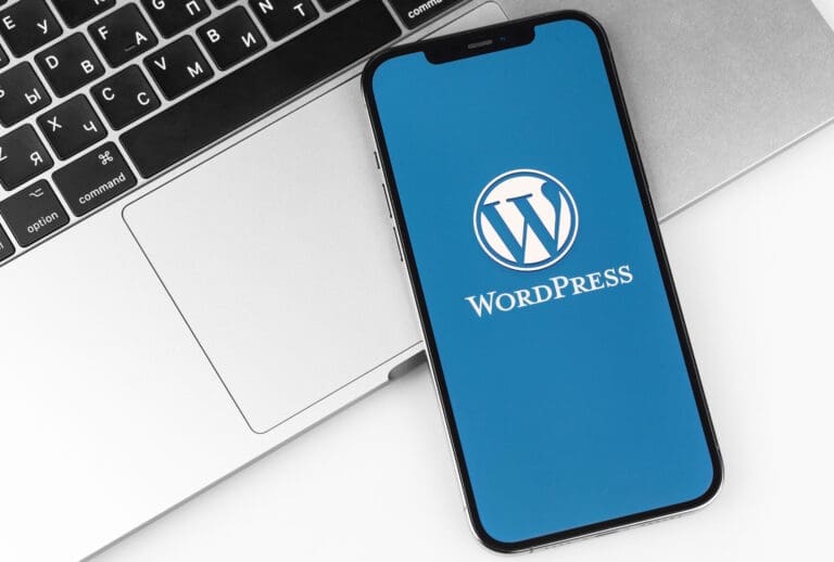 Smartphone displaying the WordPress logo on a laptop keyboard