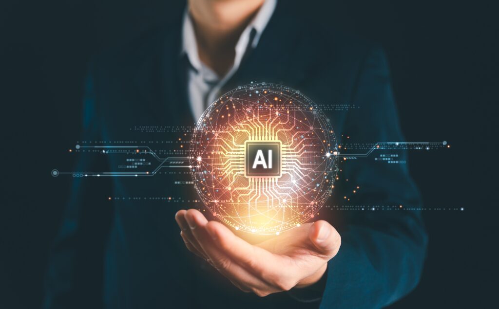 Hand holding a glowing AI symbol representing artificial intelligence technology